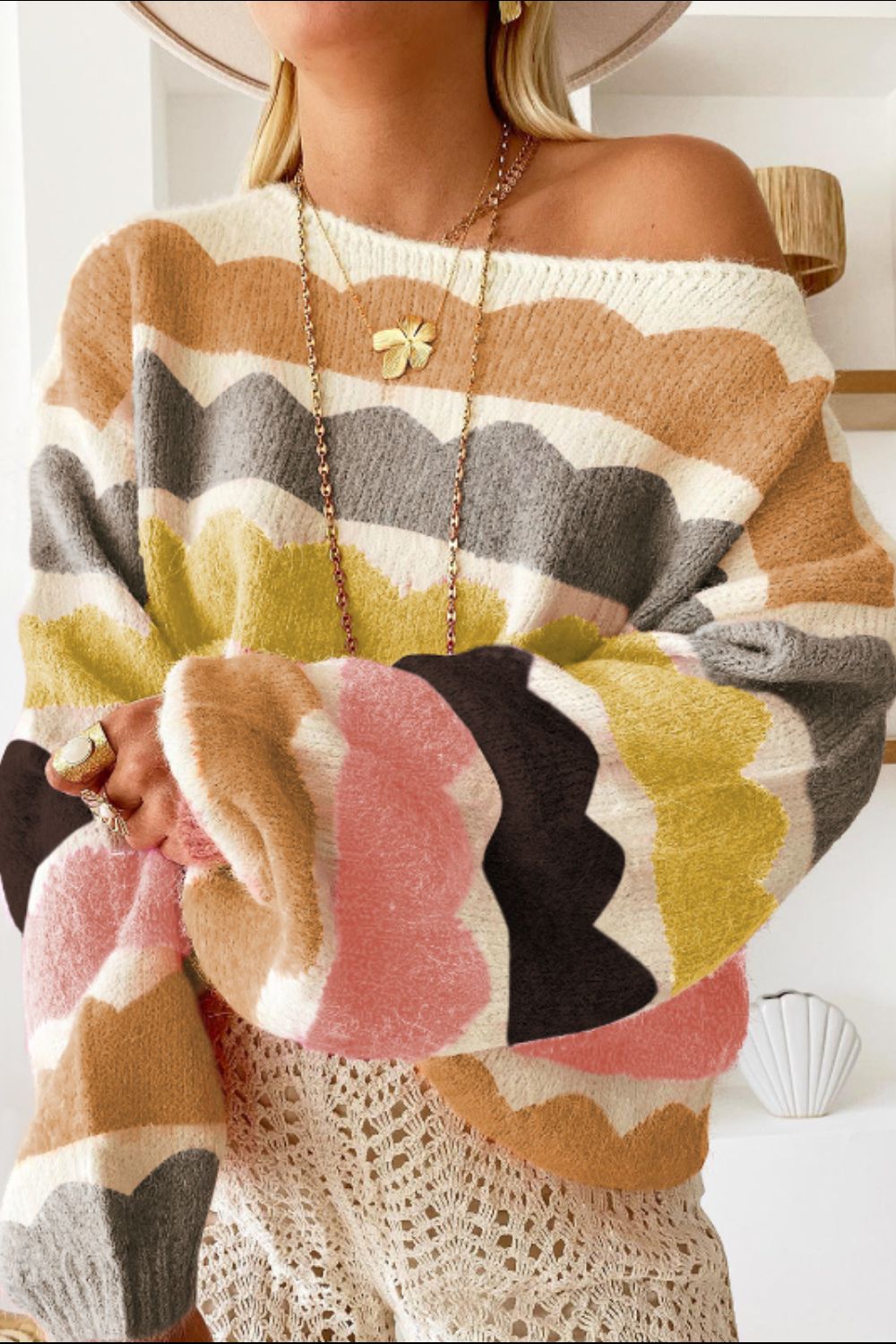 Scalloped stripe off-the-shoulder sweater in acrylic with a boatneck, featuring wavy multicolor stripes.