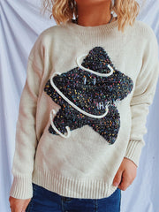 Beige knit jumper with embroidered starburst detail and white piping.