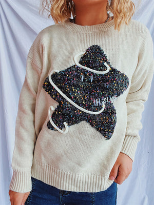 Beige knit jumper with embroidered starburst detail and white piping.