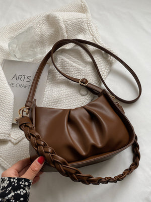 Brown ruched crossbody bag with a braided strap and adjustable shoulder strap.
