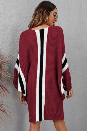 Burgundy knit cocoon dress with white and black stripe details on sleeves and back.