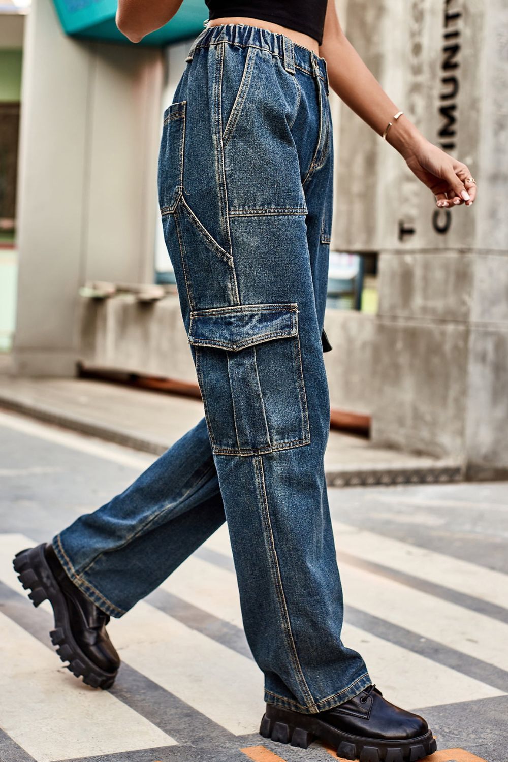 Cargo denim relaxed fit trousers in dark wash with multiple pockets and elastic waistband.