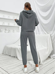 Dark gray cropped hoodie and joggers set with elastic cuffs, worn by a model.