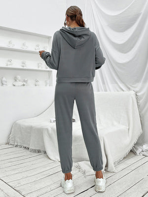 Dark gray cropped hoodie and joggers set with elastic cuffs, worn by a model.