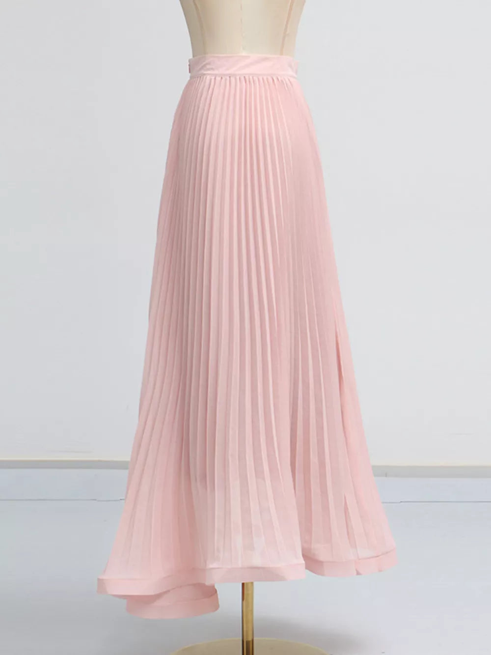 Pink pleated skirt suit with a frill collar and balloon sleeves.