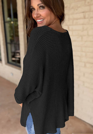 Black waffle knit V-neck sweater with slit hem and long sleeves.