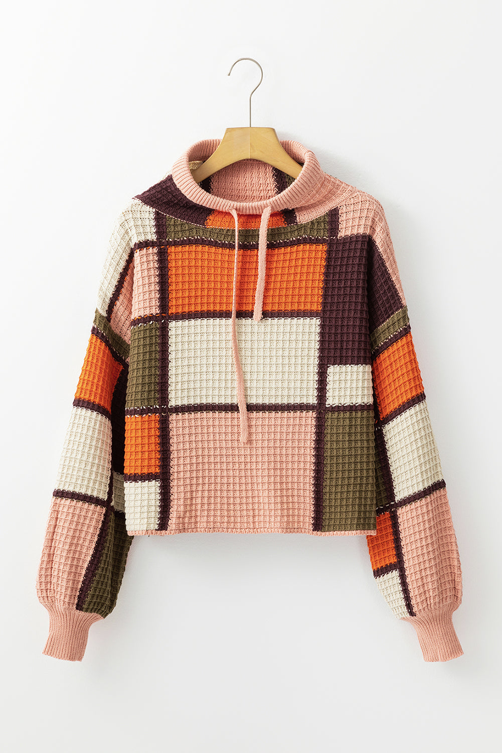 Waffle knit patchwork hoodie in orange, pink, cream, brown, and green with drawstring neck.