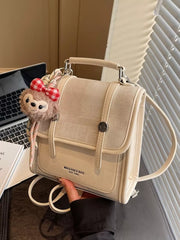 Chic mini flap backpack in cream with plush charm and red gingham bow.