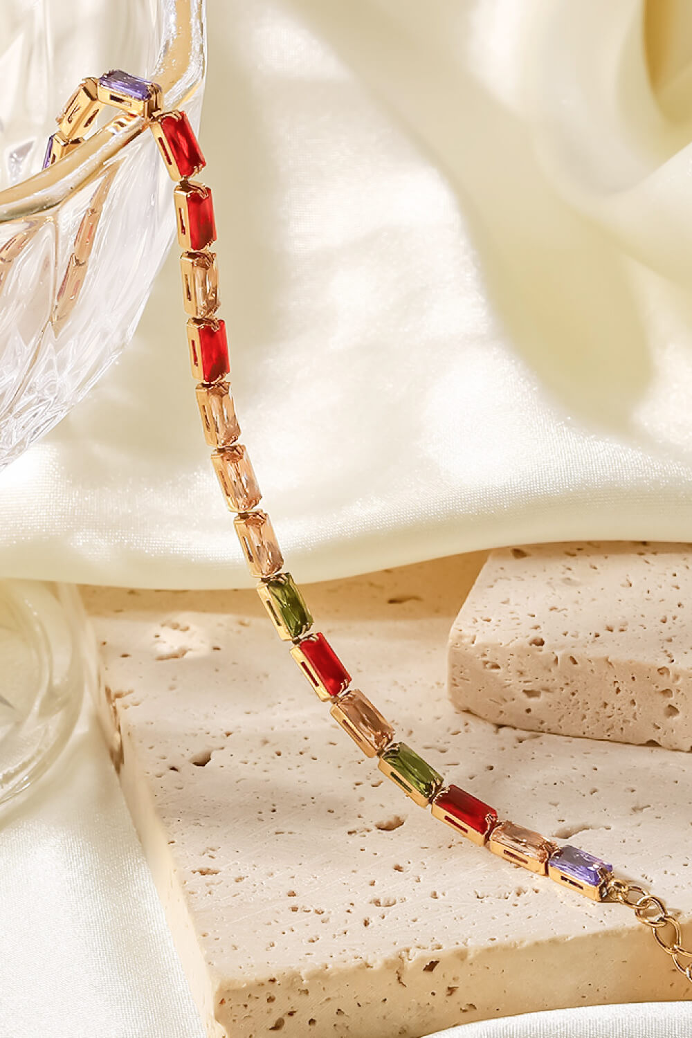 Prismatic baguette gold chain bracelet with multi-colored gemstones.