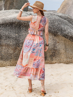 Paisley print ruffle midi dress in blush pink with patchwork details and a cinched waist.