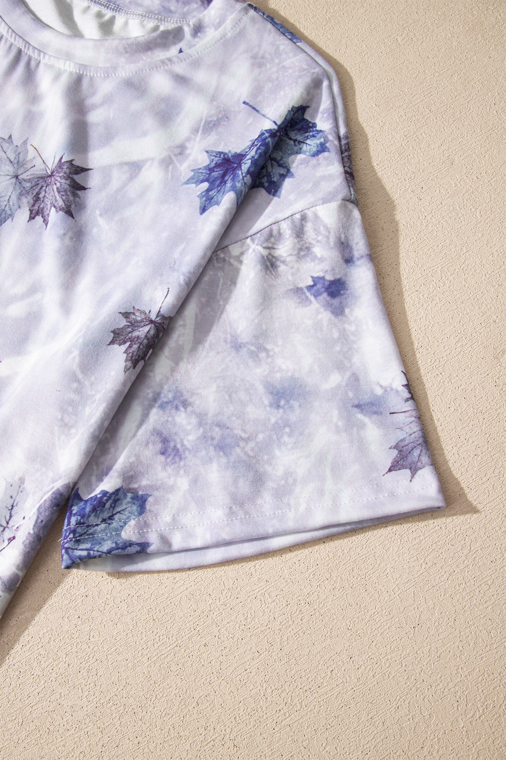 Tunic tee with purple and white tie dye and blue leaf print, crew neck, short sleeves.