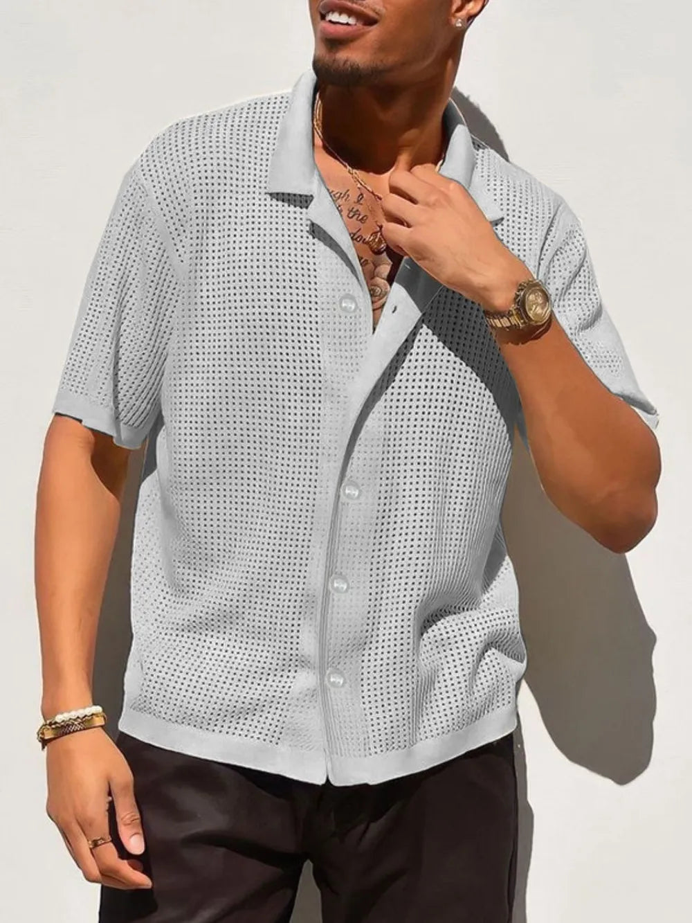 Gray perforated knit resort shirt with short sleeves and a button-up front.