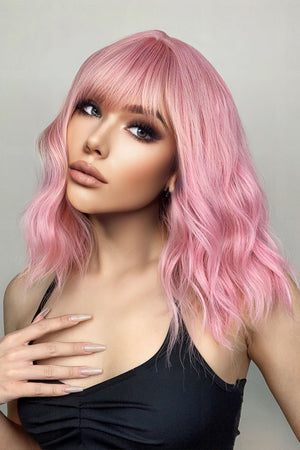 Pink bob wig with bangs and wavy texture, styled on a model.
