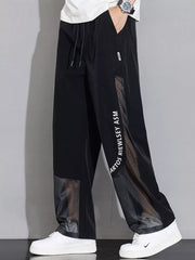 Black sweatpants with wide legs, mesh panels, and graphic text detail.