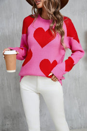 Pink knit sweater with red heart pattern, crew neck, long sleeves, acrylic.