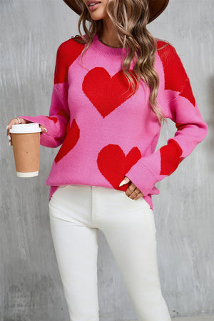 Pink knit sweater with red heart pattern, crew neck, long sleeves, acrylic.
