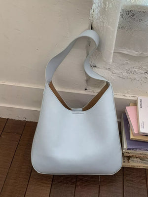 Sleek large blue pu leather shoulder bag with a curved strap and minimalist design.
