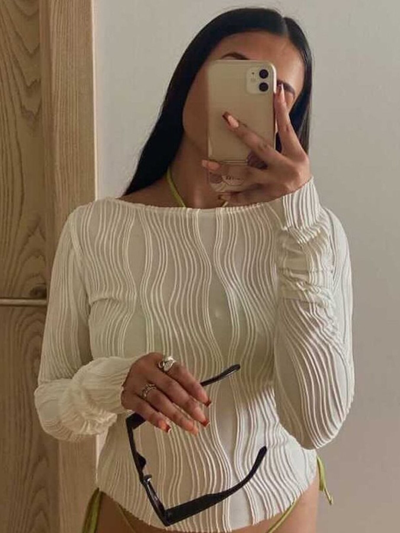Textured white fitted long sleeve blouse with asymmetrical hem and ruched cuffs.