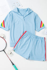 Light blue activewear set with rainbow stripe accents on sleeves and shorts.