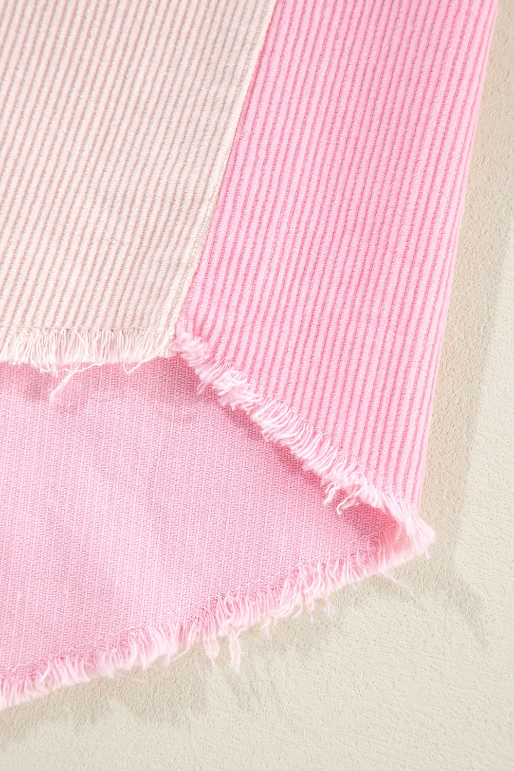 Colorblock corduroy shacket in blush pink with raw edges and vertical stripes.