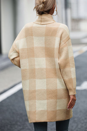 Oversized tan and cream checkerboard knit duster coat with a shawl collar and long sleeves.