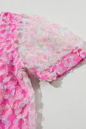 Fuchsia pink blouse with floral appliqué mesh sleeves and textured fabric.
