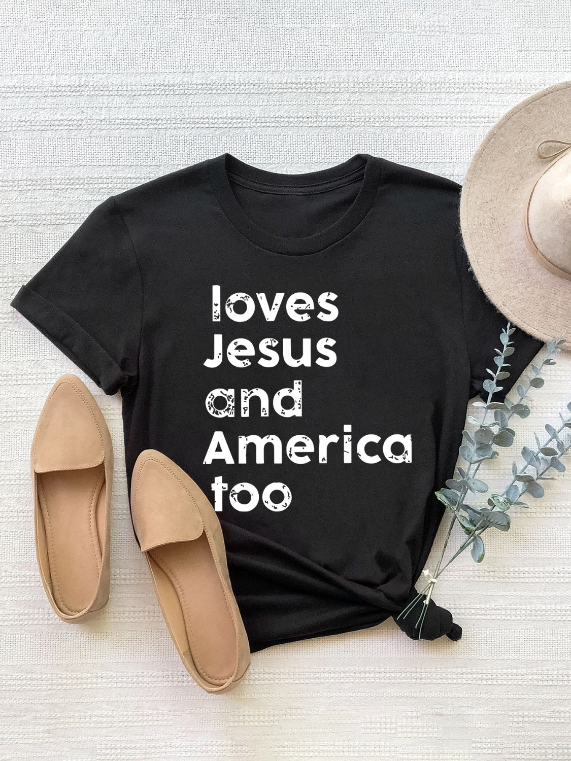 Black crew neck t-shirt with white text graphic that says "loves Jesus and America too