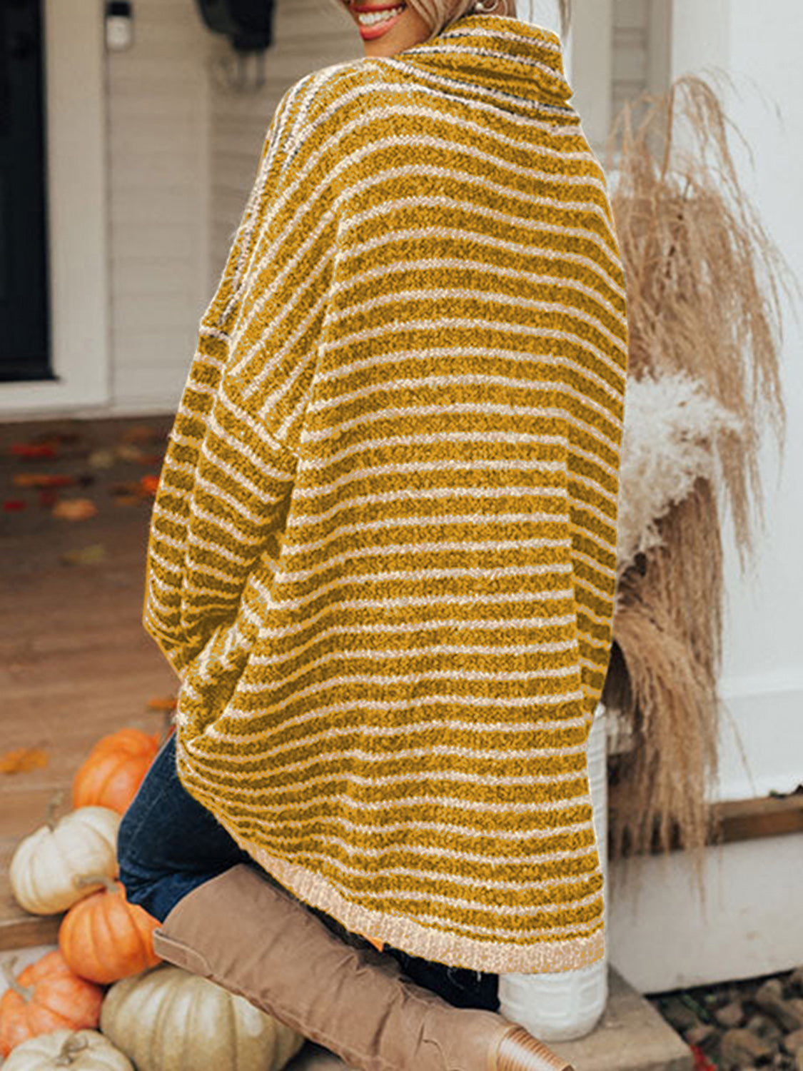 Gold striped oversized turtleneck sweater with slouch pockets, shown from the back.