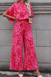 Crimson Splatter Tie-Waist Palazzo Jumpsuit in hot pink with wide legs and flutter sleeves.