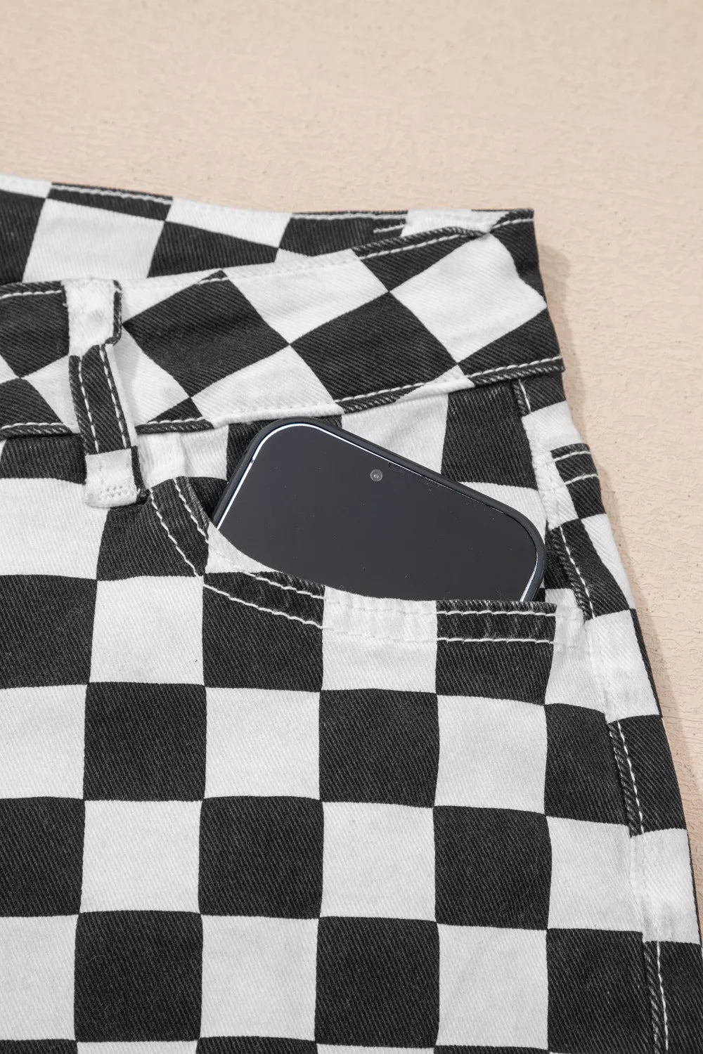 Checkerboard distressed cropped jeans with a phone in the pocket