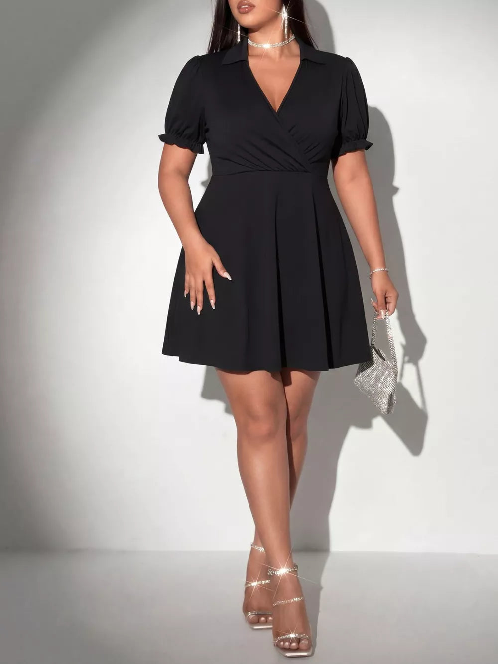 Black plus-size mini dress with surplice neckline, puff sleeves, and flared skirt.