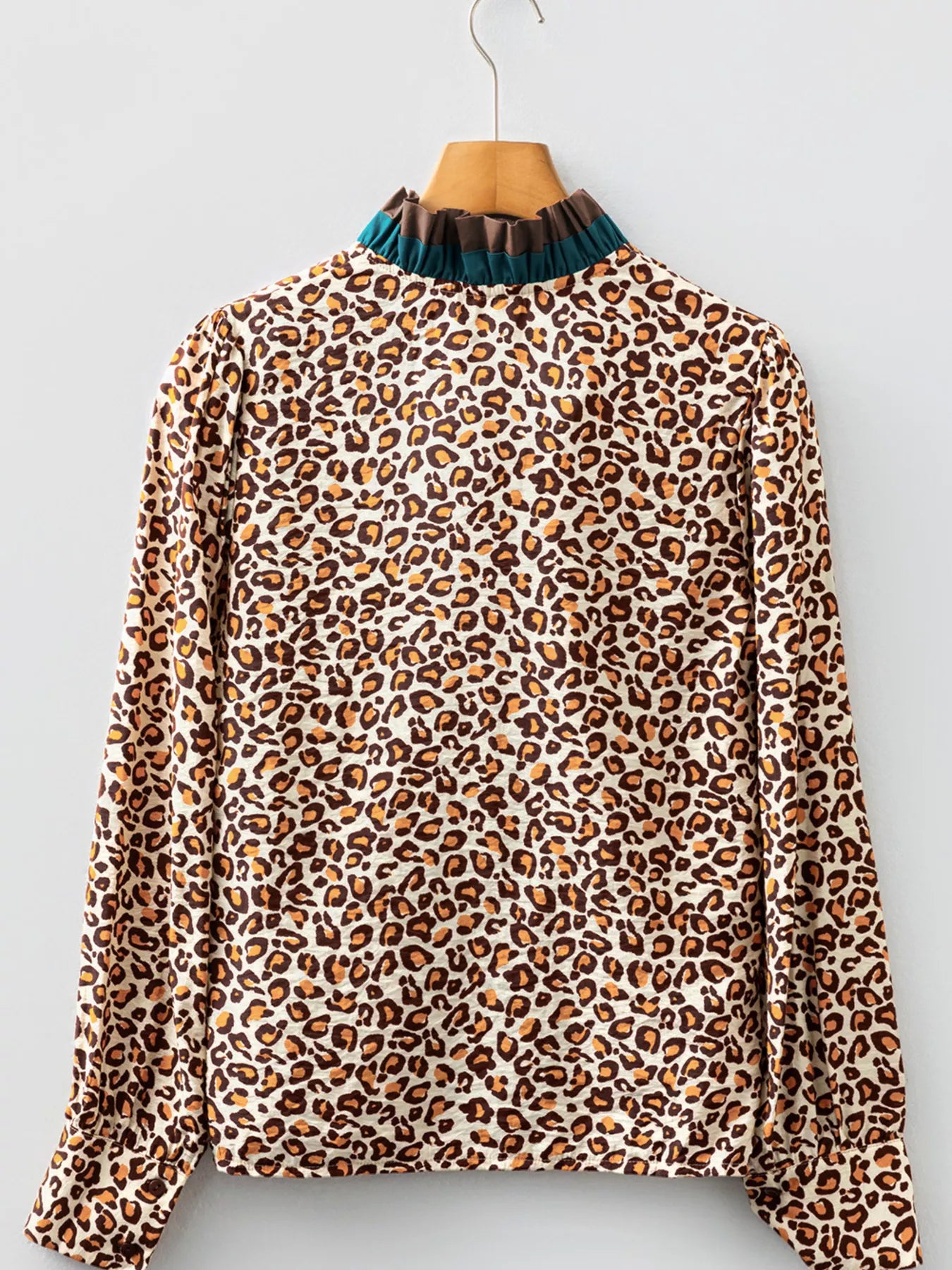 Leopard print button-down shirt with a frilled mock neck and long sleeves.