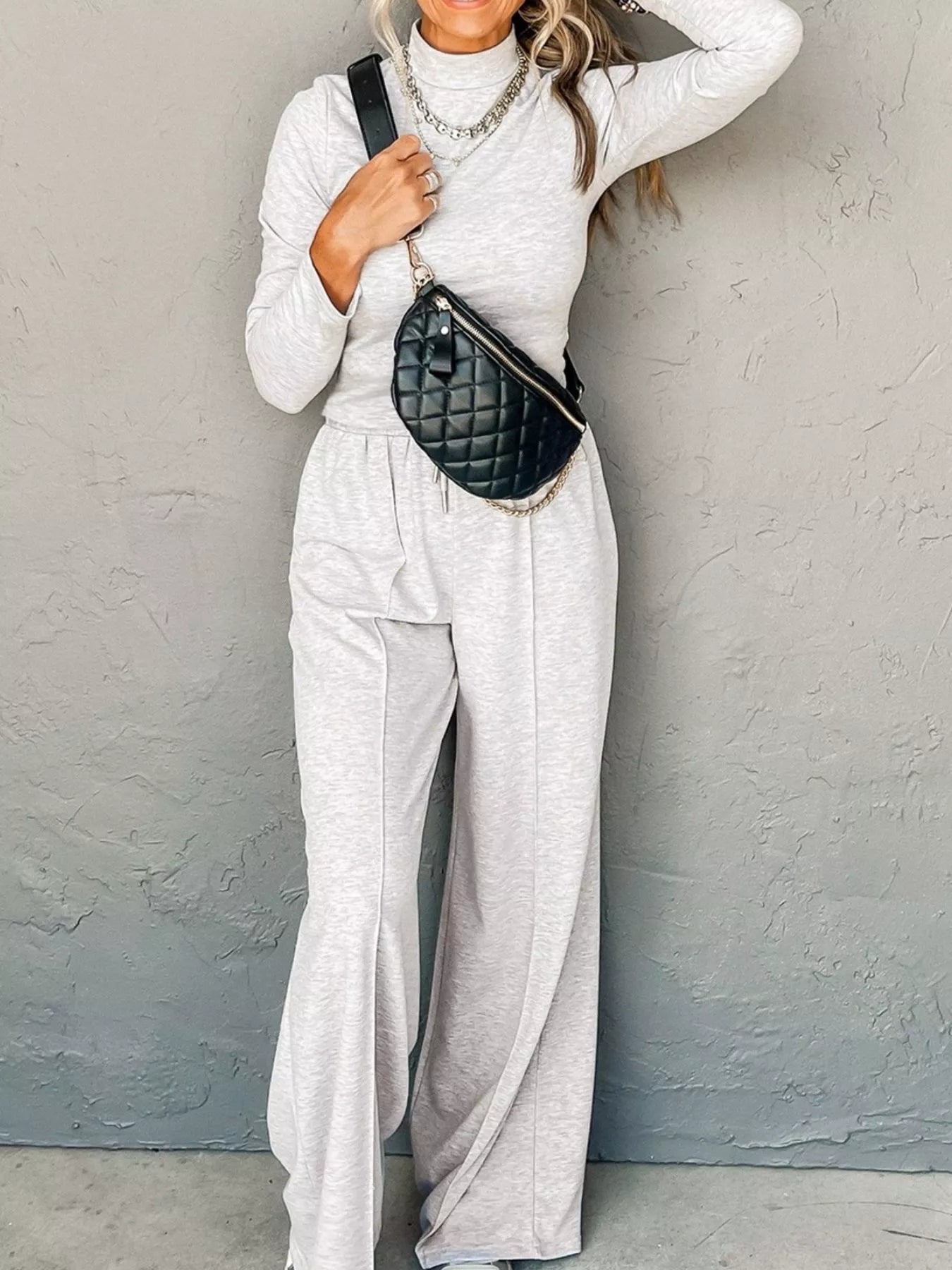 Light gray turtleneck loungewear set with drawstring pants and a quilted fanny pack.