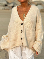 Beige bouclé oversized button-down cardigan with V-neck, pockets, and textured knit.