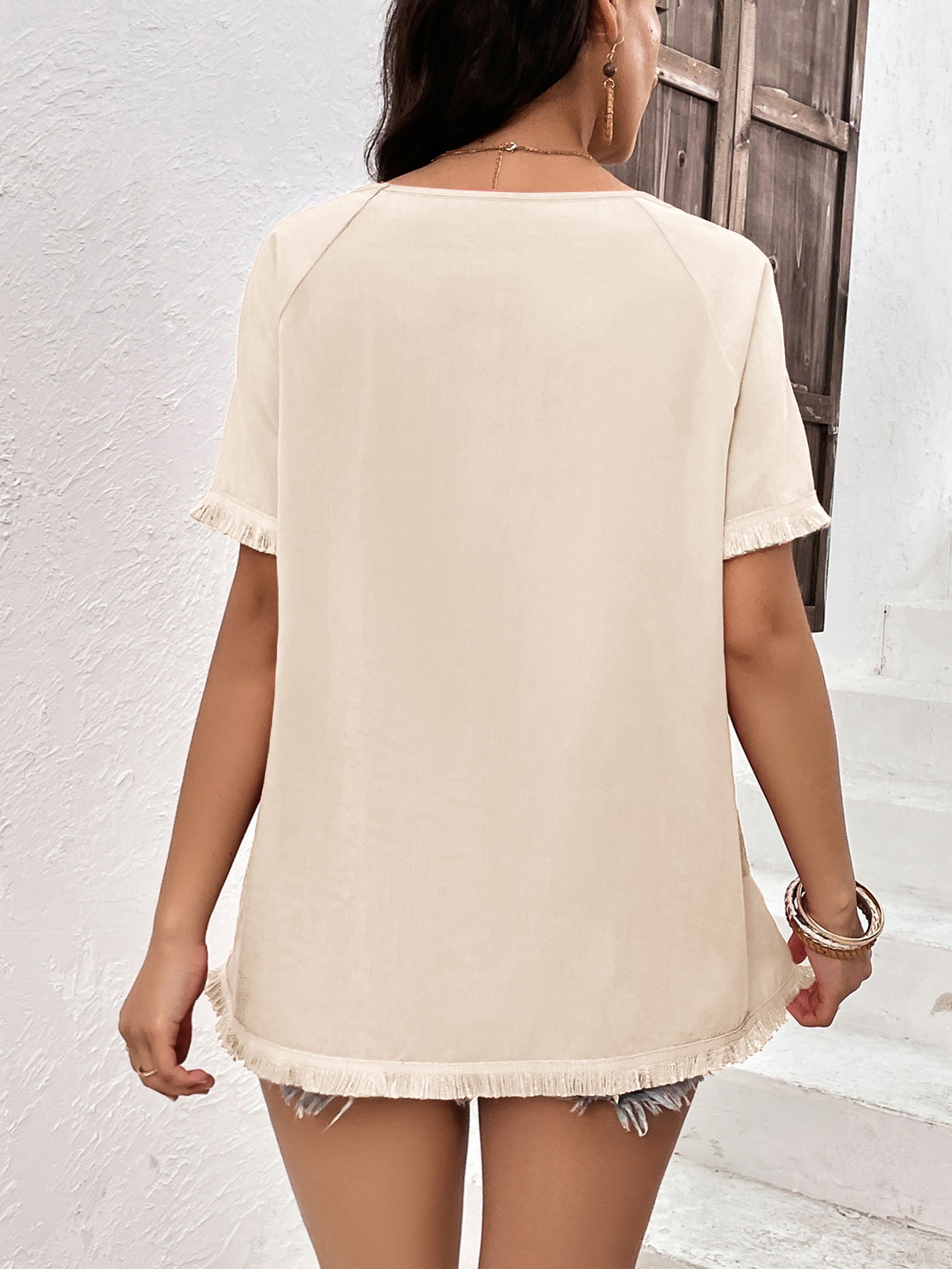 Cream raglan sleeve tee with fringed hem and neckline detail.