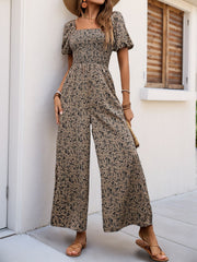 Taupe floral smocked bodice palazzo jumpsuit with square neckline and puff sleeves.