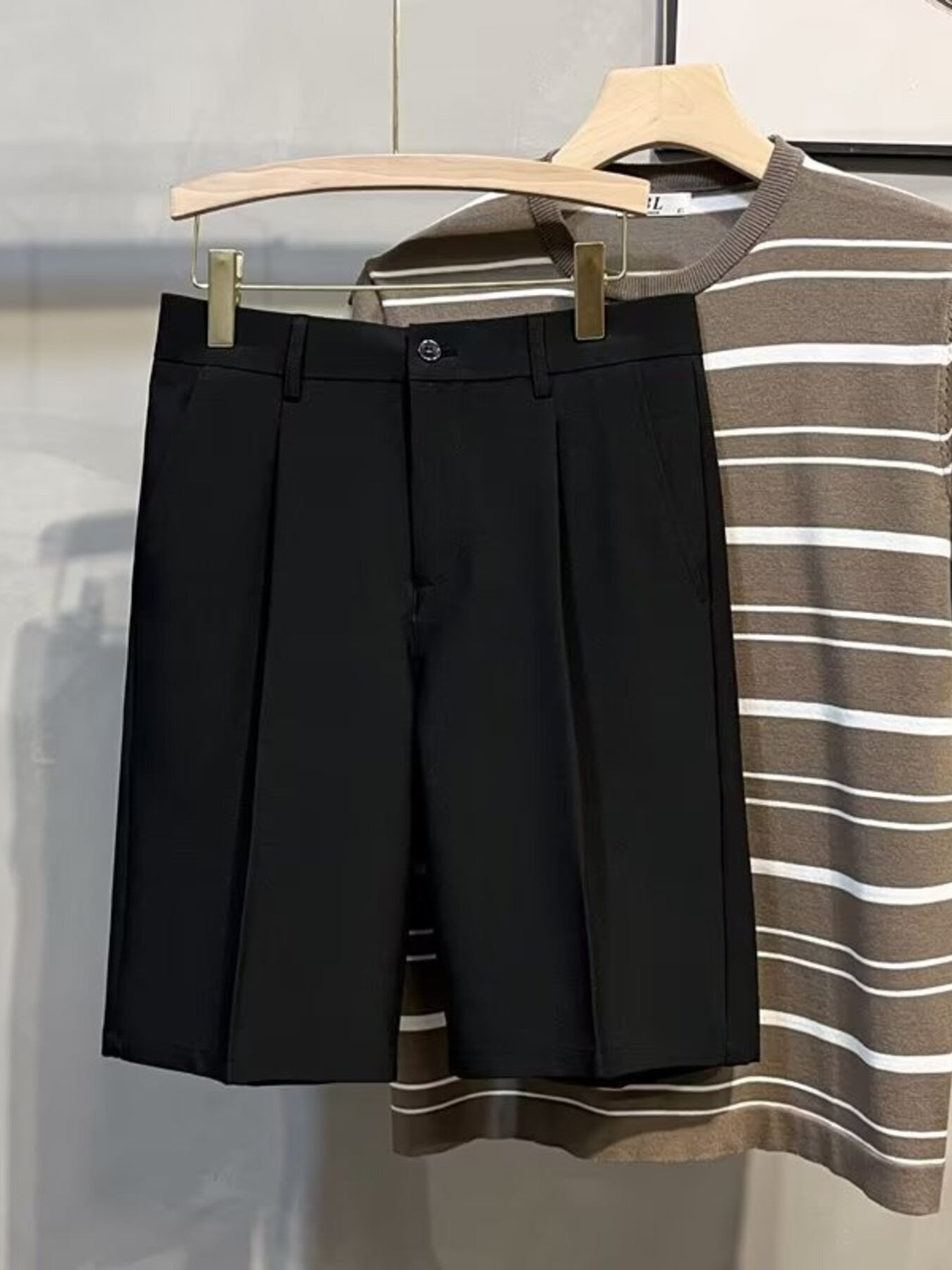 Black pleated front casual chino shorts with a button and zip closure.