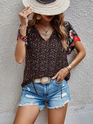 Bohemian floral print blouse with flutter sleeves and V-neck in multicolor.