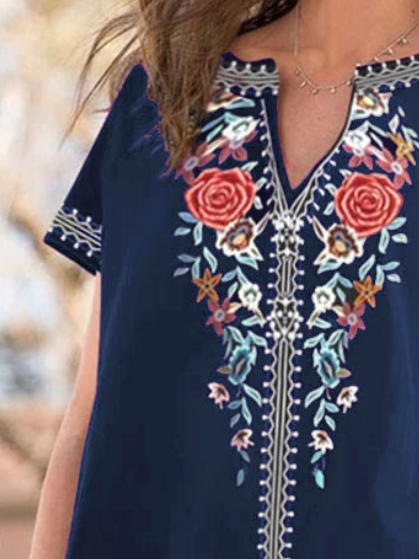 Navy blue blouse with floral embroidery and notched neckline
