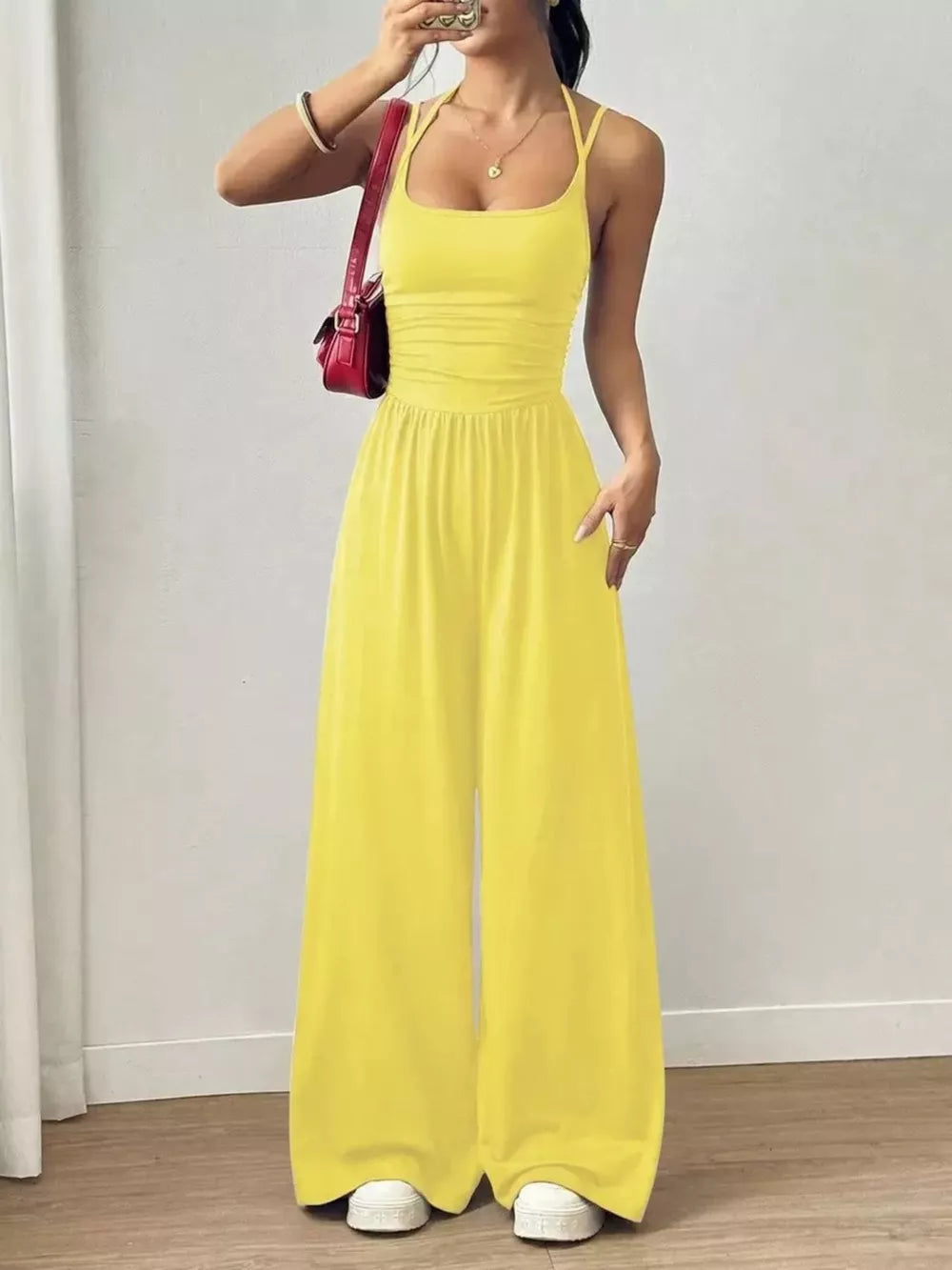 Yellow ruched wide-leg jumpsuit with spaghetti straps and a square neckline.