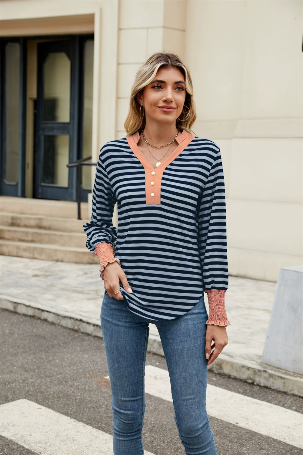 Striped long sleeve blouse with orange neckline and cuffs, henley button detail