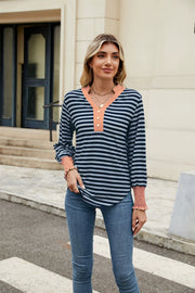 Striped long sleeve blouse with orange neckline and cuffs, henley button detail