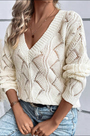 Ivory openwork knit V-neck pullover sweater with diamond pattern and ribbed cuffs.