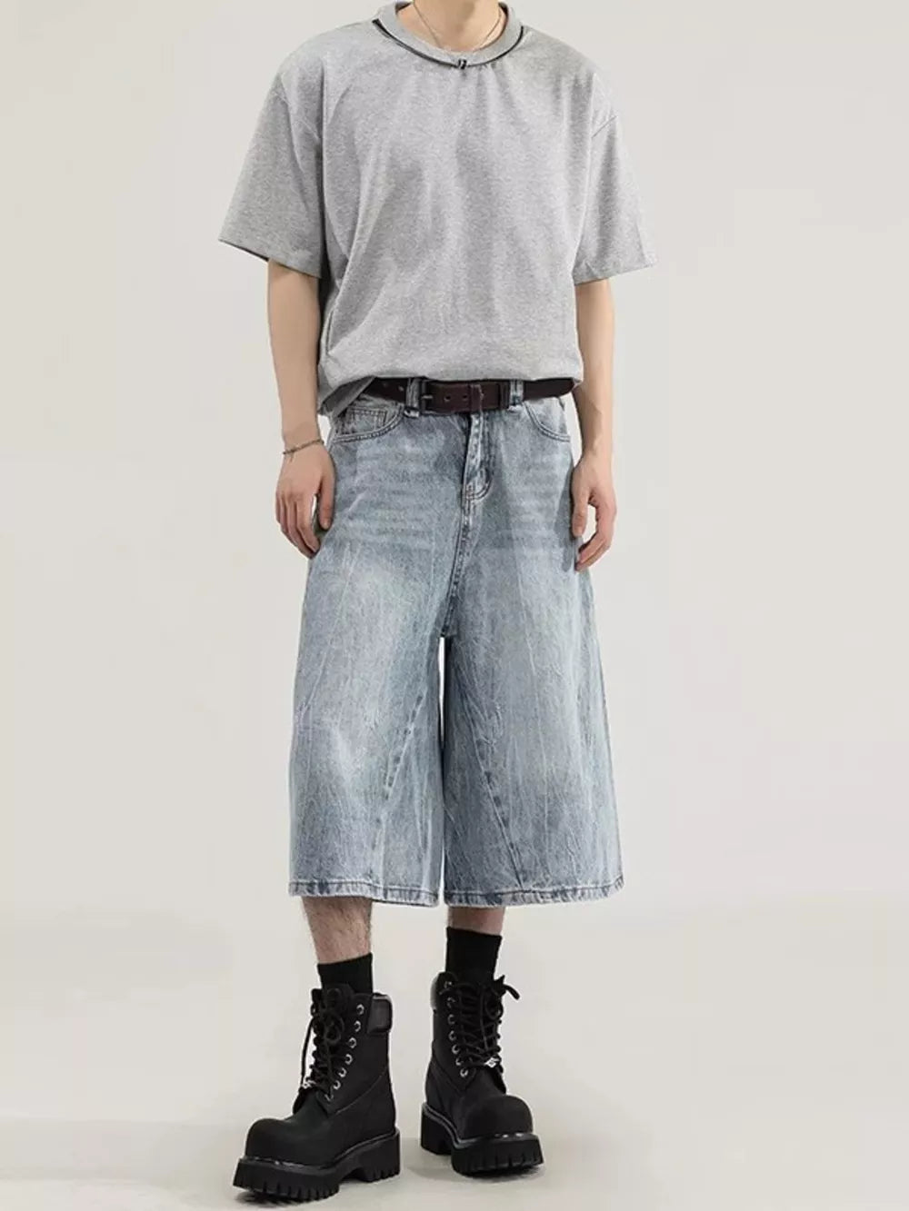 Men's light wash denim capris with a relaxed fit and wide leg, styled with a grey t-shirt and black boots.