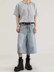 Men's light wash denim capris with a relaxed fit and wide leg, styled with a grey t-shirt and black boots.