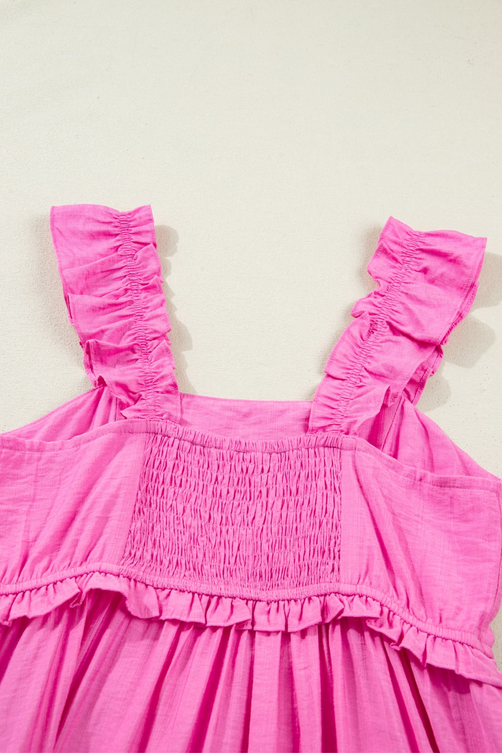 Pink ruffled sleeveless maxi dress with smocked bodice and tiered hem.