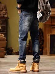 Distressed blue cotton jeans with cuffed hems and embroidered accents.