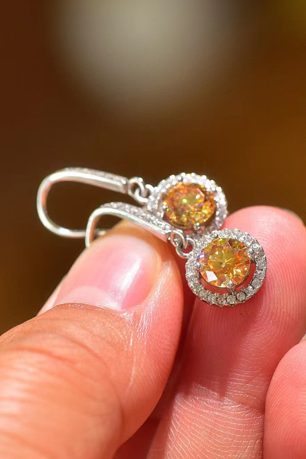 Golden halo moissanite drop earrings with yellow center stones and white diamond accents.