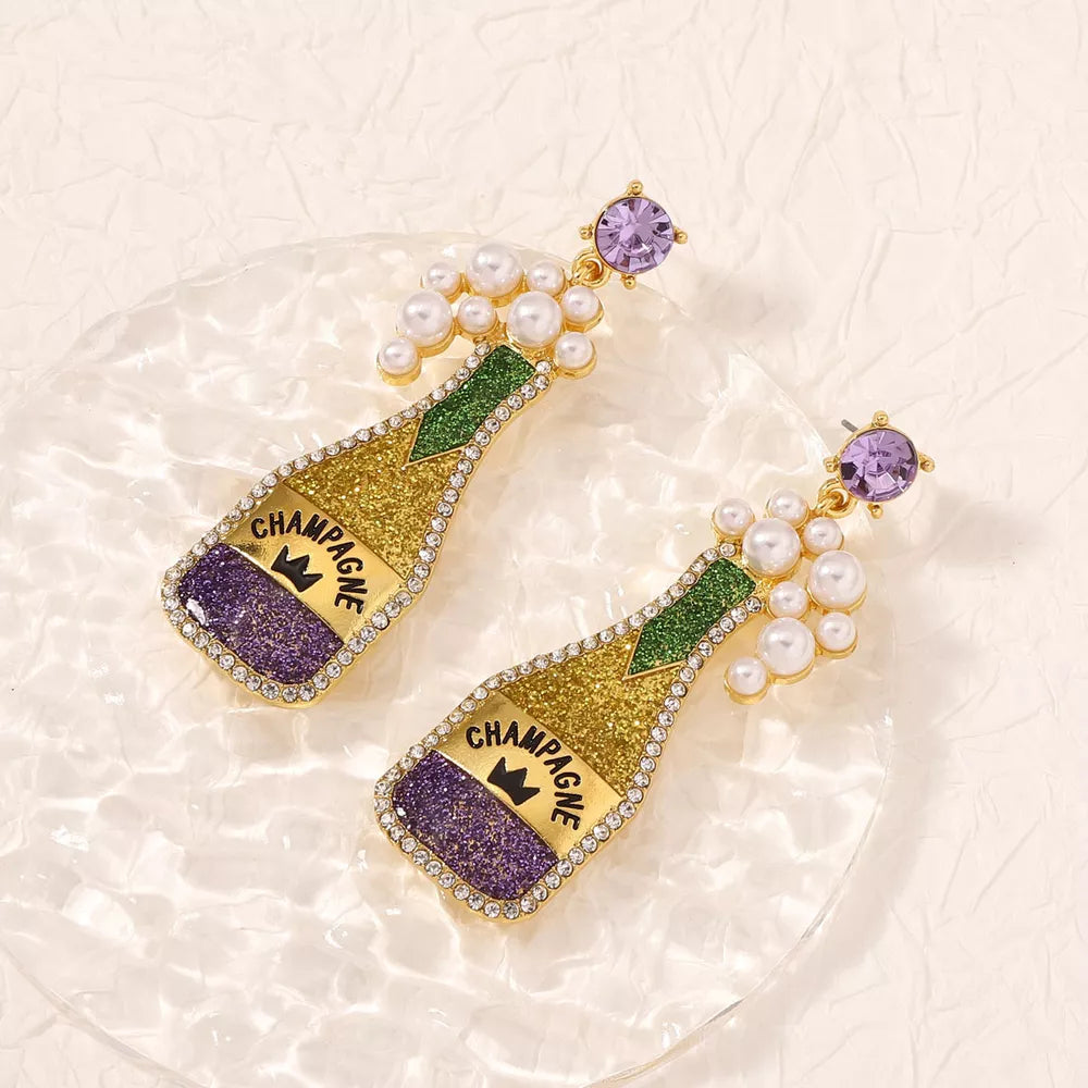 Champagne bottle drop earrings with purple and gold glitter, pearls, and purple gems.