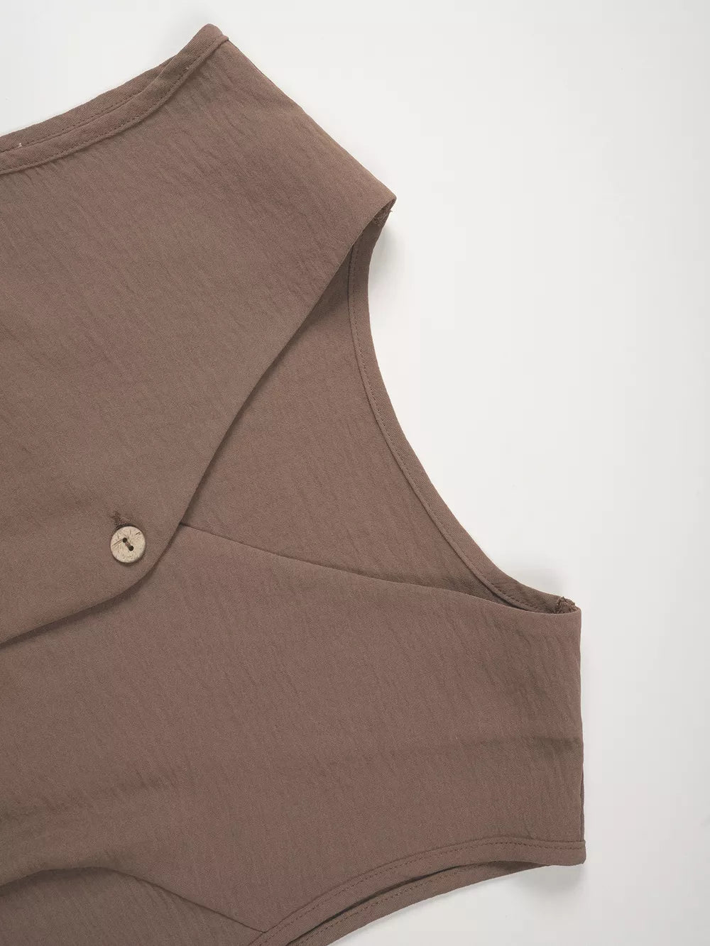 Taupe cropped vest with button detail and wide-leg pants ensemble.